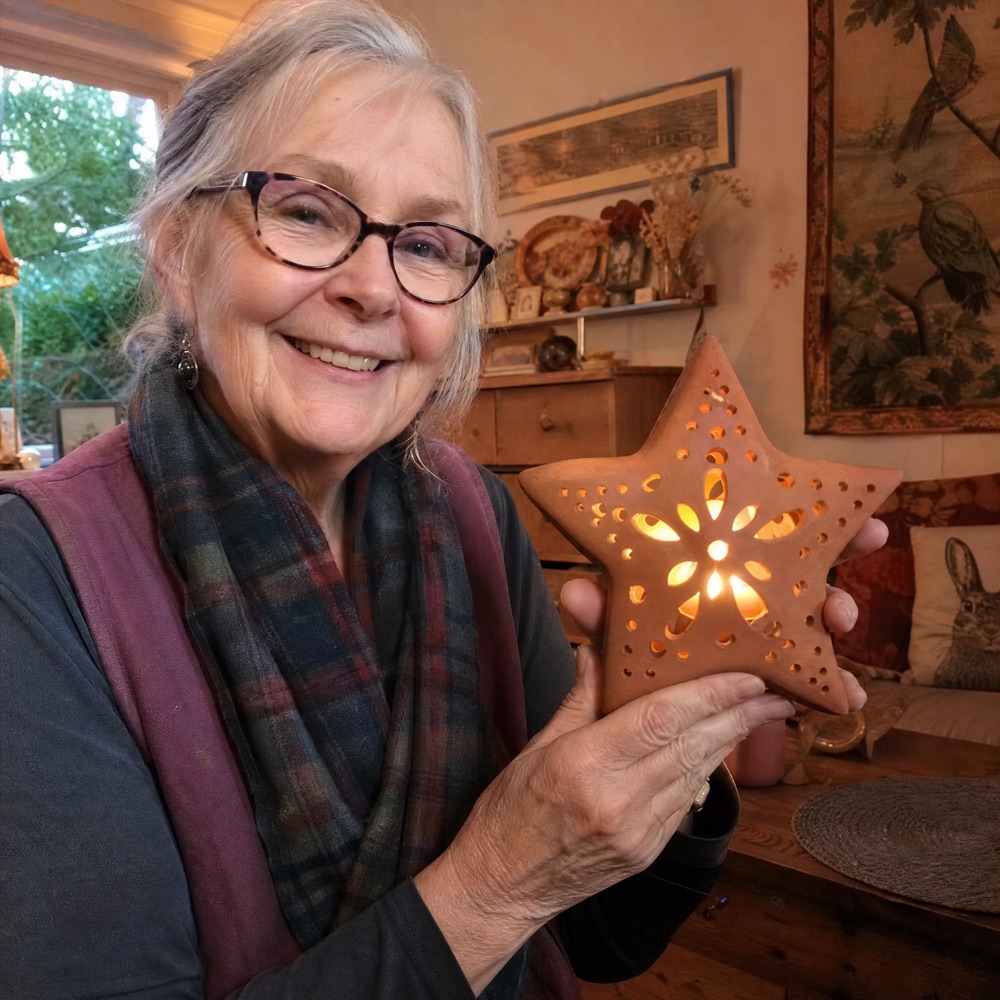 Barbara W. holding her handmade ceramic piece at home